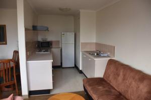 a living room with a couch and a kitchen at Accommodation Sydney City Centre - 2 Bedroom Pet Friendly Apartment with Hyde Park View in Sydney