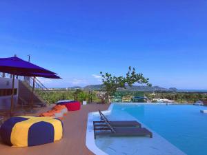 uma piscina com uma cama e um guarda-sol em The Blue Hotel - SHA Plus em Chalong