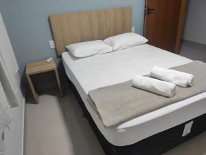 a bed with two pillows on top of it at Apartamento One 360° in Capitólio