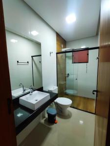 a bathroom with a sink and a toilet at Apartamento One 360° in Capitólio +11 photos