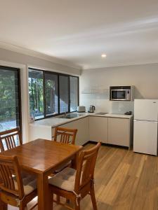 a kitchen and dining room with a wooden table and chairs at Clouds Mapleton in Mapleton