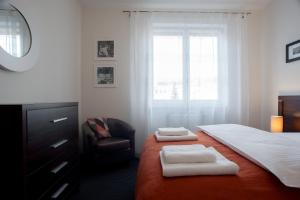 sypialnia z łóżkiem, krzesłem i oknem w obiekcie Apartamenty Starówka - Melody w Szczecinie