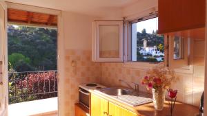 a kitchen with a sink and two windows at Skiathos Studios Panorama in Skiathos