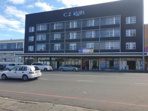 a large building with cars parked in a parking lot at Modern Oxford Street Apartment - 40 CZ KUBS in East London