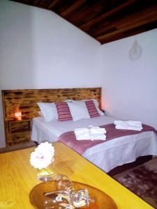 a bedroom with a large bed and a table at Chalé Sonho Diniz 1 in Monte Verde