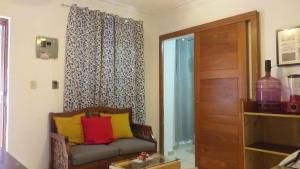 sala de estar con sofá y almohadas amarillas y rojas en small apartment, en Santo Domingo