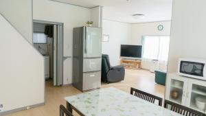 een woonkamer met een koelkast en een televisie bij サザンコースト湘南 in Chigasaki