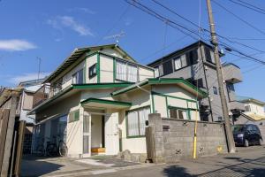 een wit en groen huis in een straat bij サザンコースト湘南 in Chigasaki