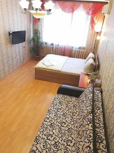 a bedroom with a bed and a television and a window at Sovetskaya 50 in Tomsk