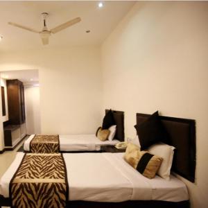 a hotel room with two beds and a tv at Regency Square Hotel in Gwalior +49 photos