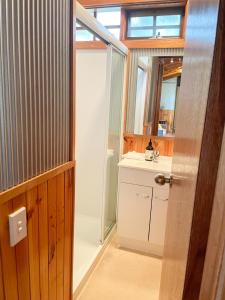 a bathroom with a sink and a mirror at Port Bayou Cottage in Port Campbell