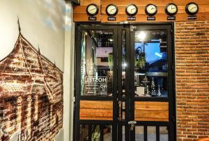 a door to a restaurant with clocks on the wall at The 8 Factory Hotel Phitsanulok in Phitsanulok