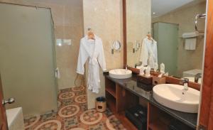 a bathroom with two sinks and a shower and a mirror at Sunset Palace View Suites in Mandalay