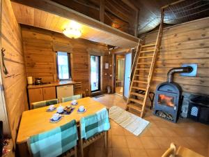 a dining room with a table and a wood stove at Sodyba Duburiai in Ukmergė