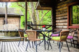 einen Tisch und Stühle auf einer Veranda einer Hütte in der Unterkunft Sodyba Duburiai in Ukmergė
