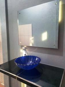 eine blaue Schüssel auf einer Theke unter einem Spiegel in der Unterkunft Kurnia Homestay in Ternate