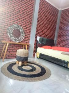 a bedroom with a bed and a carpet with aigunigunigun at Kurnia Homestay in Ternate