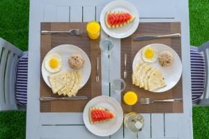 a table with plates of eggs and fruit on it at La Palma Villa in Ukulhas