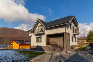 a house with a black roof at Nikol in Turitsa