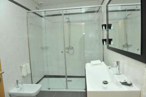 uma casa de banho com um chuveiro, um lavatório e um WC. em Pensão Santo António em Vila Nova de Famalicão