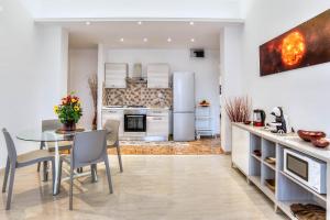 cocina y comedor con mesa y sillas en Appartamenti LUNA e SOLE, en Roma