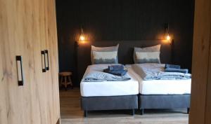 2 camas con sábanas blancas y toallas azules. en Herz3 Hotel Bar Restaurant Trattoria, en Hollersbach im Pinzgau