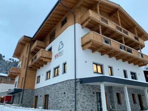 un edificio con balcones de madera encima en Herz3 Hotel Bar Restaurant Trattoria, en Hollersbach im Pinzgau