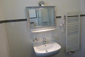 ein Bad mit einem Waschbecken und einem Spiegel in der Unterkunft Villa Luise in Hameln