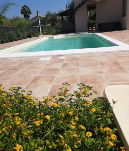 ein Pool mit Blumen vor einem Haus in der Unterkunft Villa Giorgia 2020 in Cefalú