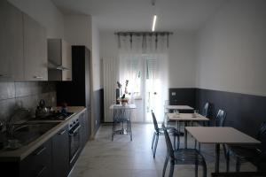 een keuken met een tafel en stoelen en een keuken met een wastafel en een tafel bij PVrooms in Campobasso