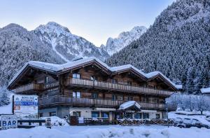 una cabaña de madera en las montañas en la nieve en Alpen Chalet en Schilpario