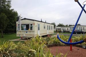 a small white caravan parked in a park at Great Deals at The Grange, Ingoldmells in Skegness