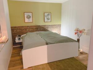 a bedroom with a white bed in a room at Ferienhaus Rauschenbachmühle in Arnsfeld