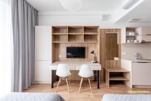 a room with a desk and two white chairs at Apartament w Warszawie dedykowany parking podziemny w cenie, WiFi, blisko centrum New apartment in Warsaw finished to a high specification fitted out to a high standard on the 7th floor, WiFi, underground parking price included in Warsaw