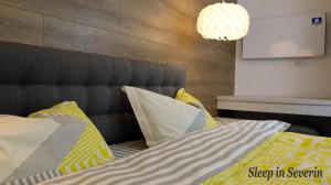 1 dormitorio con 1 cama con almohadas amarillas y grises en Apartament ULTRACENTRAL 2 en Drobeta-Turnu Severin