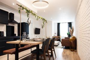a dining room and living room with a table and chairs at L’Intemporel 40 in Châteauroux
