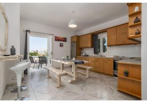 a kitchen with wooden cabinets and a table in it at Soto's Comfort House in Adamas