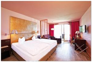 - une chambre avec un grand lit blanc dans l'établissement Hotel Karnerhof, à Egg am Faaker See