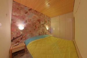 1 dormitorio con cama amarilla y pared de flores en Apartment 217, en Hohegeiss