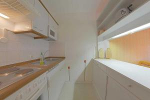 cocina blanca con fregadero y encimera en Apartment 217, en Hohegeiss
