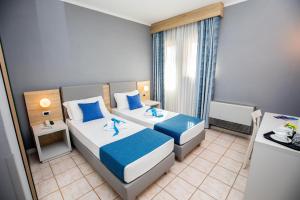 una camera d'albergo con due letti e una finestra di Bike&Boat Argentario Hotel a Porto Santo Stefano