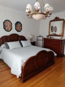 um quarto com uma grande cama de madeira e um espelho em San Pedroko Bidea em Alsasua