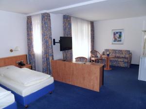 a hotel room with a bed and a tv at Hotel Stadt Homburg in Homburg