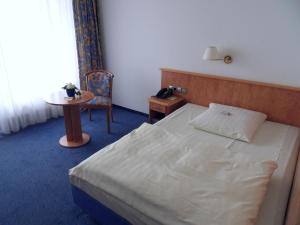 a bedroom with a bed, a desk and a lamp at Hotel Stadt Homburg in Homburg