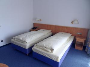 two beds in a room with a blue wall at Hotel Stadt Homburg in Homburg