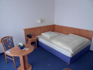 a small bedroom with a bed and a table at Hotel Stadt Homburg in Homburg