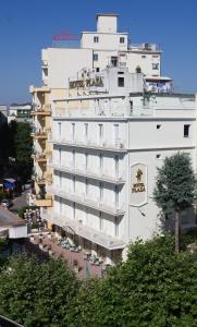 a large white building with people on the balcony at Hotel Plaza in Gabicce Mare