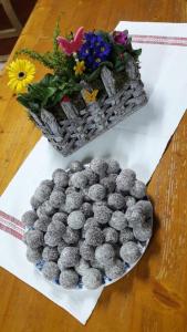 une assiette de boules grises sur une table avec des fleurs dans l'établissement Pensiunea Rozalia, à Criţ