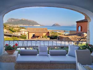 a couch on a balcony with a view of the ocean at Le case del golfo in Golfo Aranci