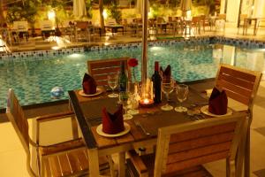 a dining table with wine glasses and a pool at Resort De Coracao - Calangute , Goa in Calangute
